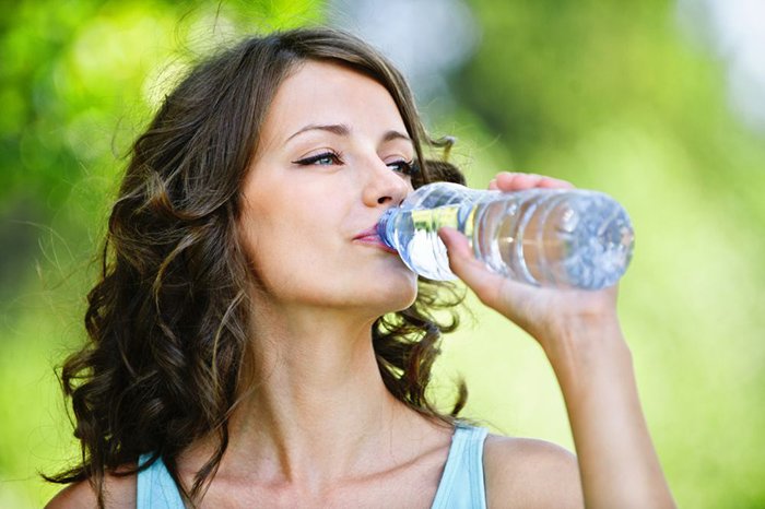 девушка пьет воду из бутылки 