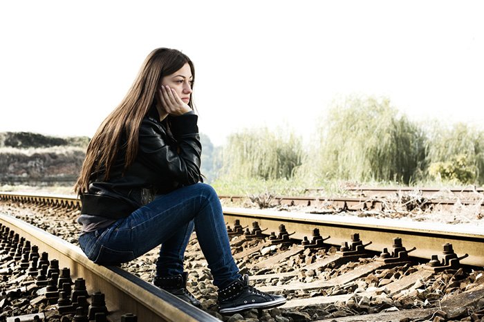девушка сидит на железной дороге 