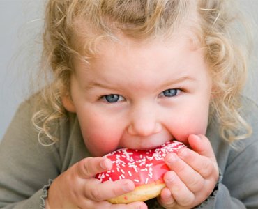 ребенок ест пончик