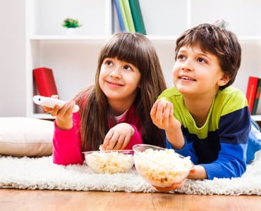 дети едят попкорн и смотрят фильм