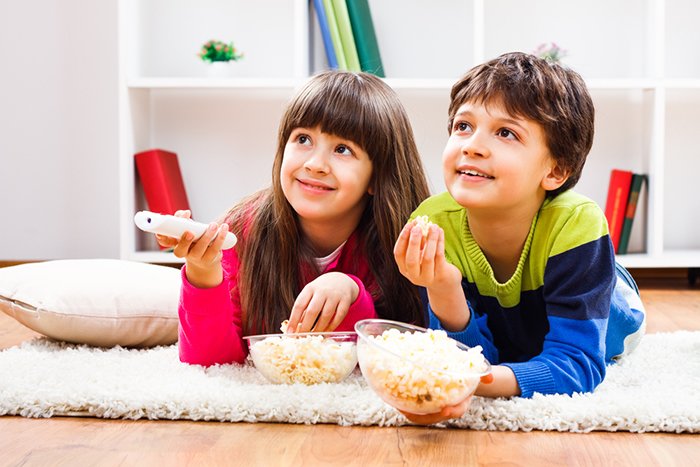 дети едят попкорн и смотрят фильм 